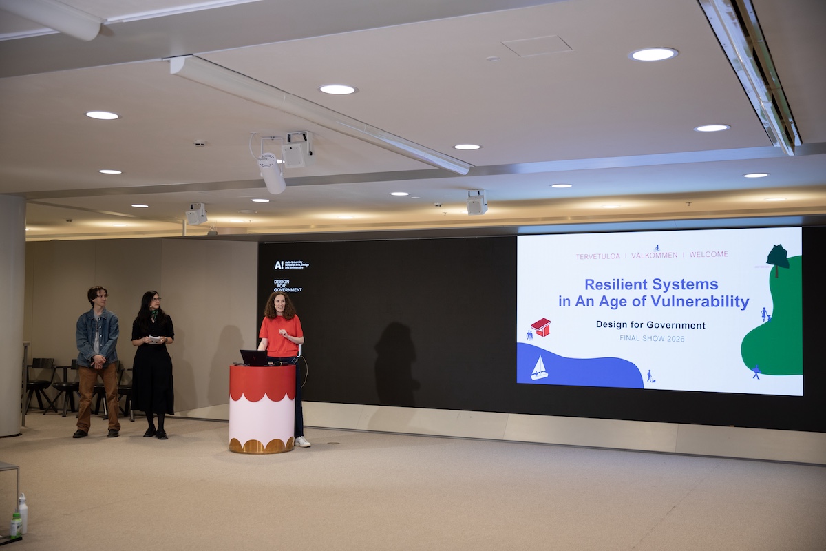 Three people in front of a screen with presentation
