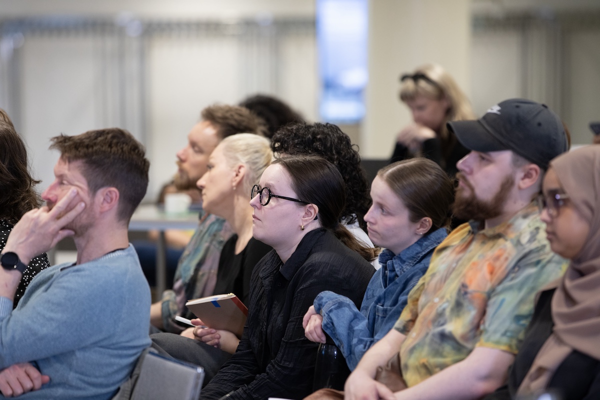 Multiple audience members observing the presentation